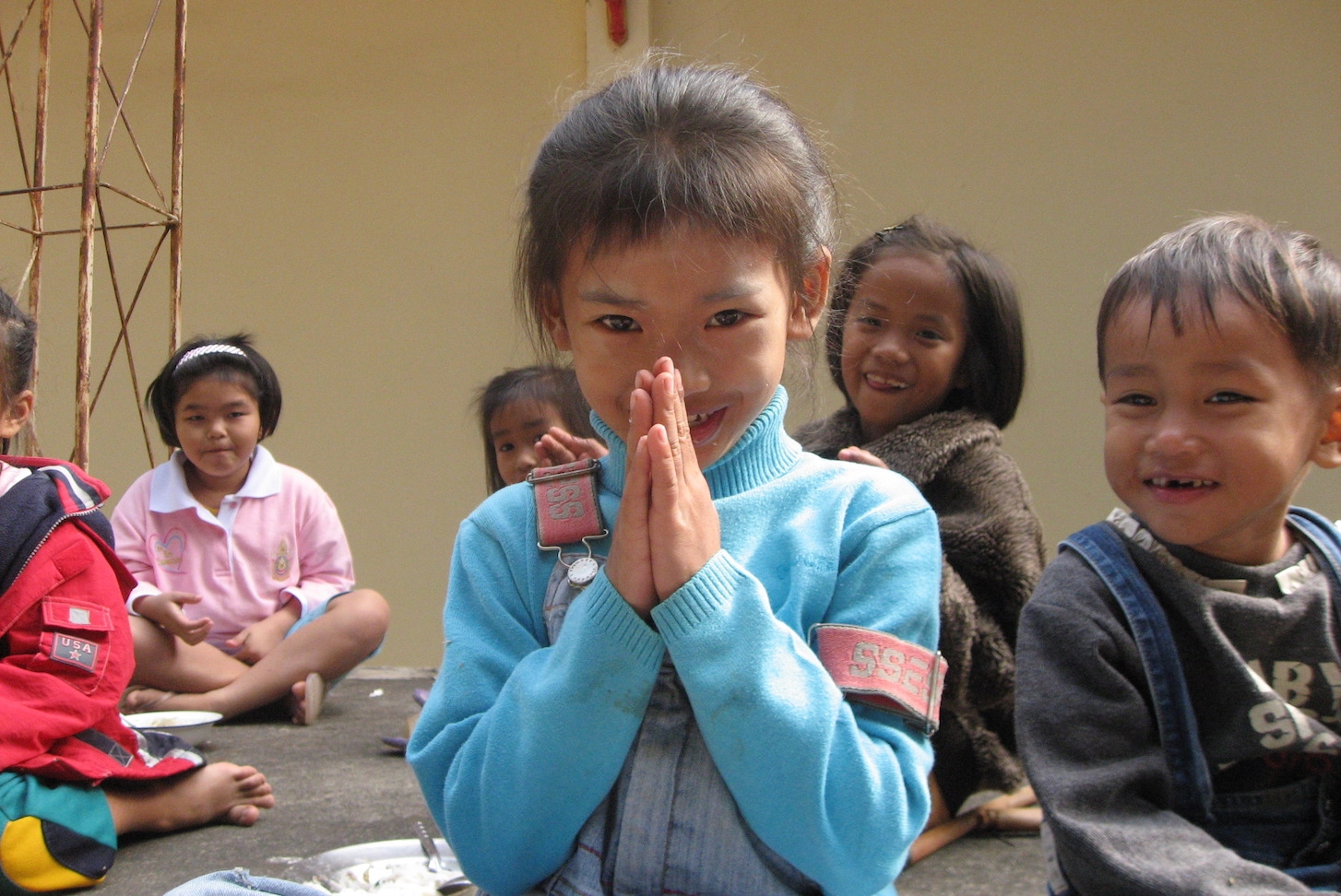 A girl demonstrates how to "wai" in Thailand. 